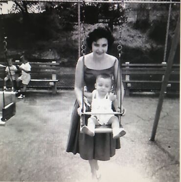 Baby in swing with mother pushing