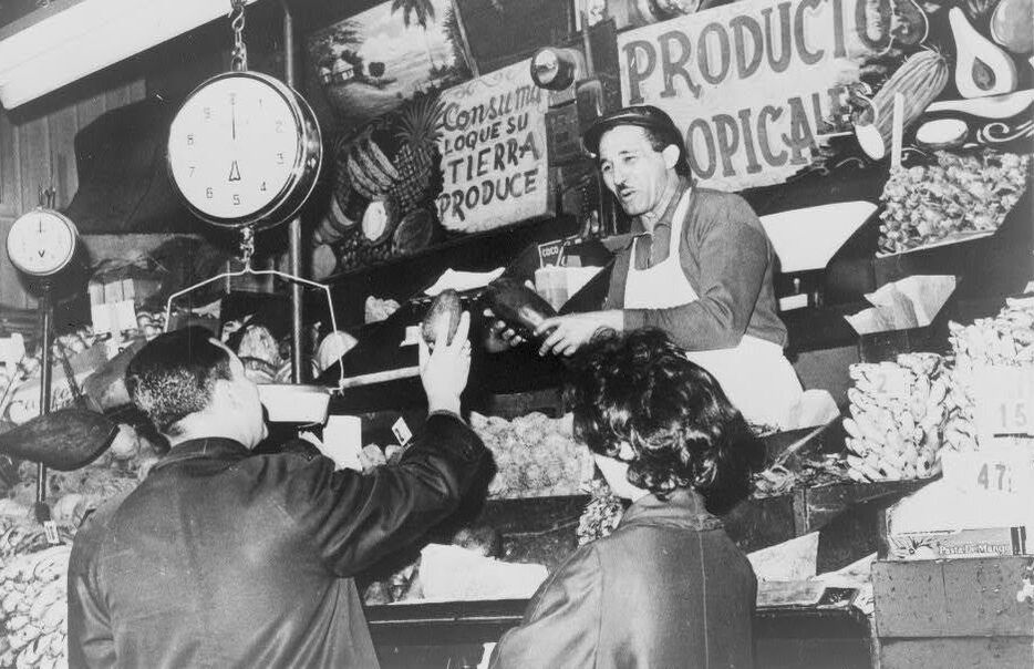Store clerk selling to patron in La Marqueta may-64