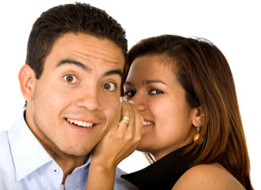 woman whispering in a man's ear